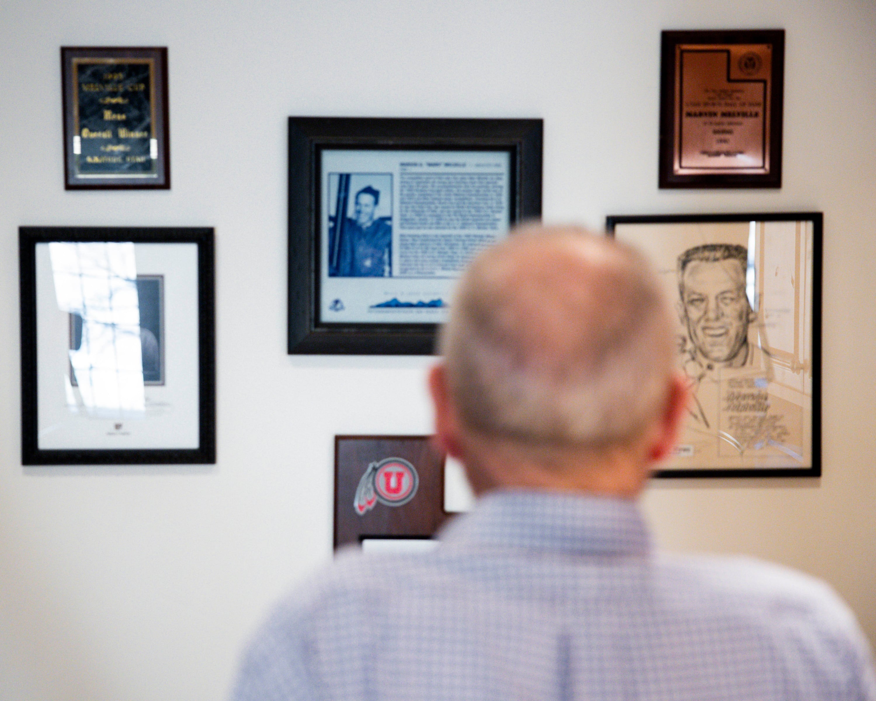 Marvin Melville looks at awards and press clippings hanging on the wall at his home in Cottonwood Heights on Dec. 15, 2025.