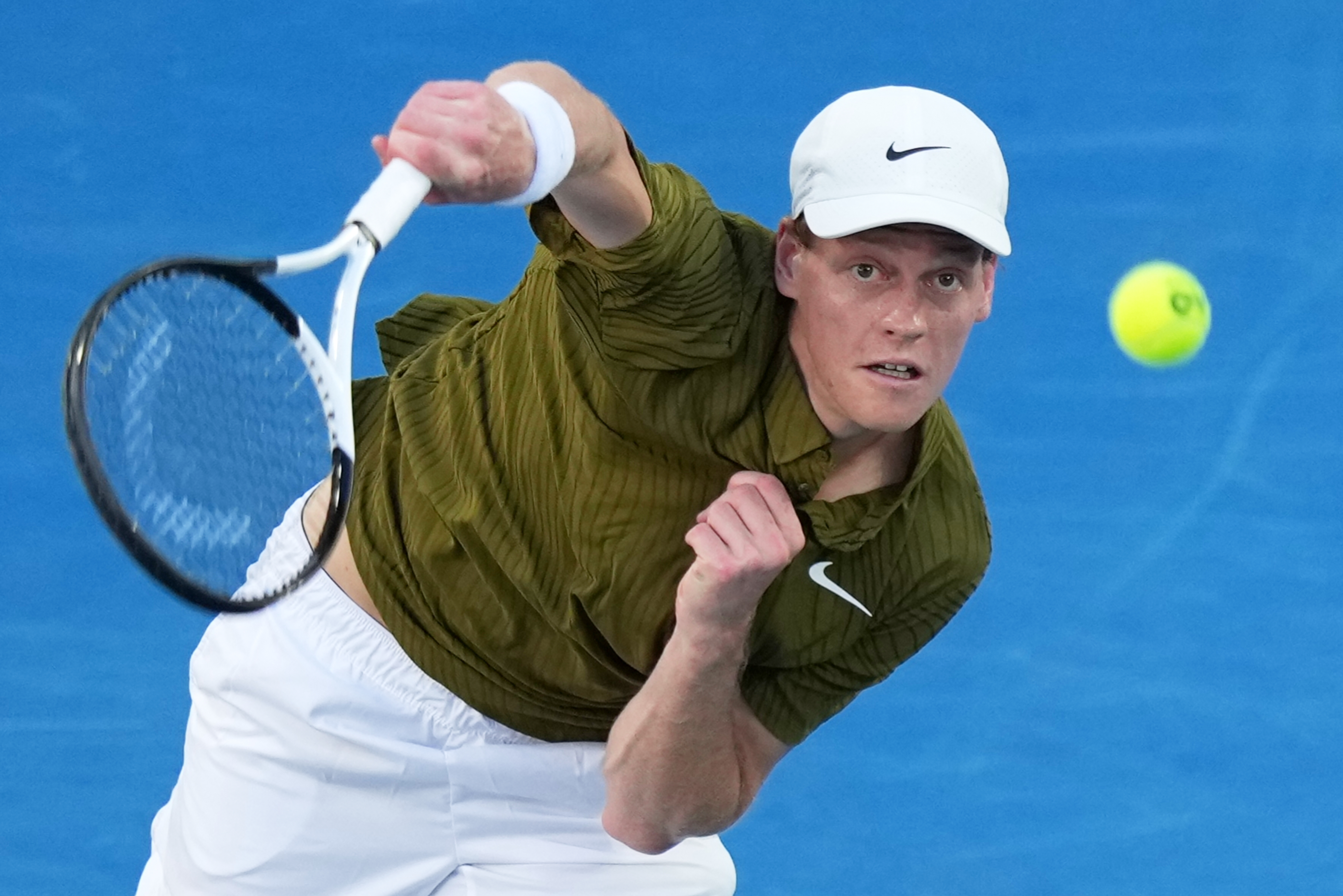 Jannik Sinner of Italy serves to his compatriot Luciano Darderi during their fourth round match at the Australian Open tennis championship in Melbourne, Australia, Monday, Jan. 26, 2026. 