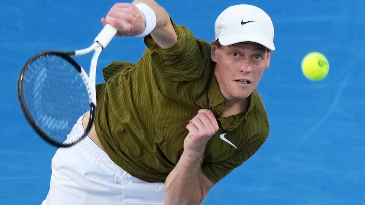 Jannik Sinner of Italy serves to his compatriot Luciano Darderi during their fourth round match at the Australian Open tennis championship in Melbourne, Australia, Monday, Jan. 26, 2026.