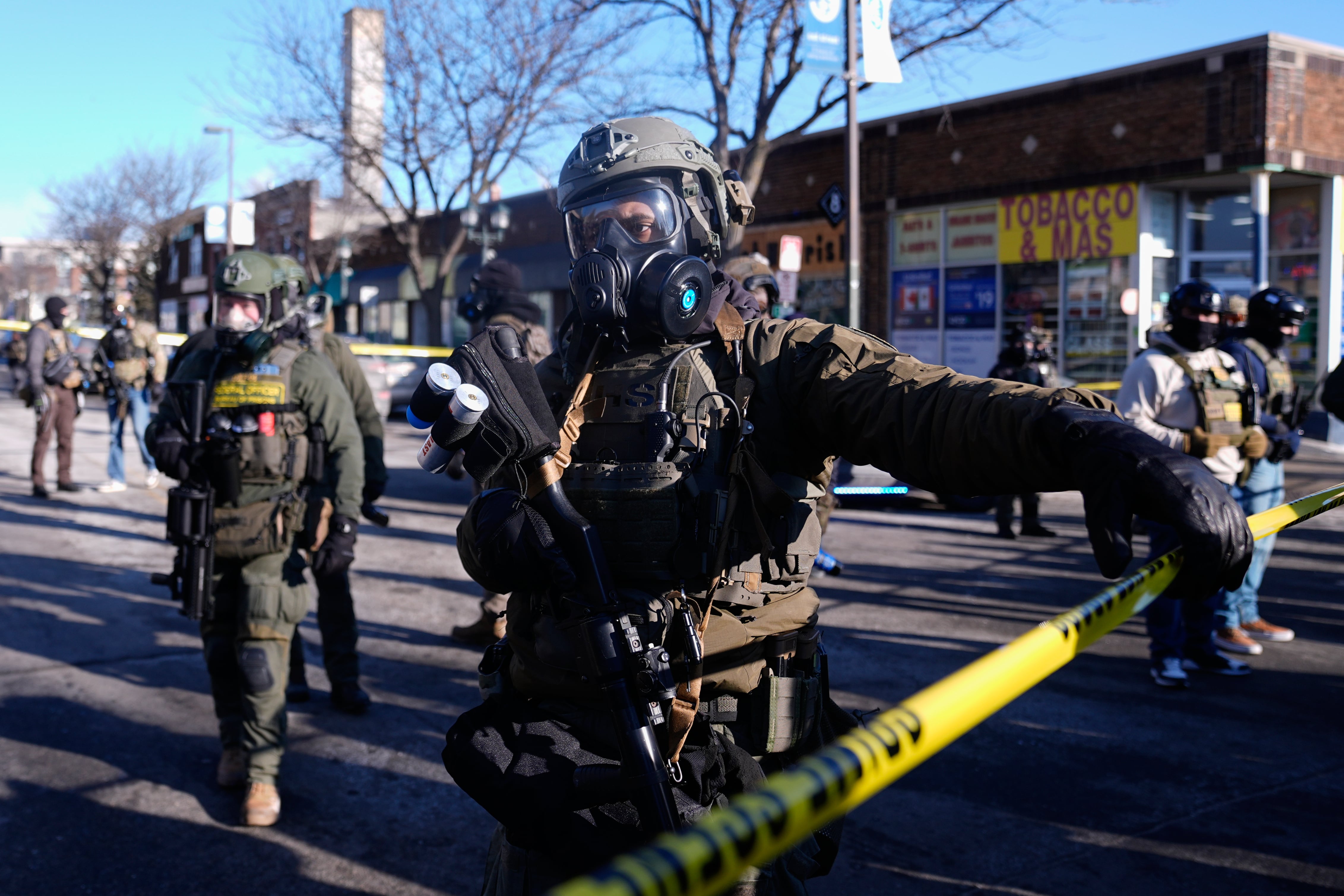 Federal agents stand near the site of a shooting Saturday, in Minneapolis.