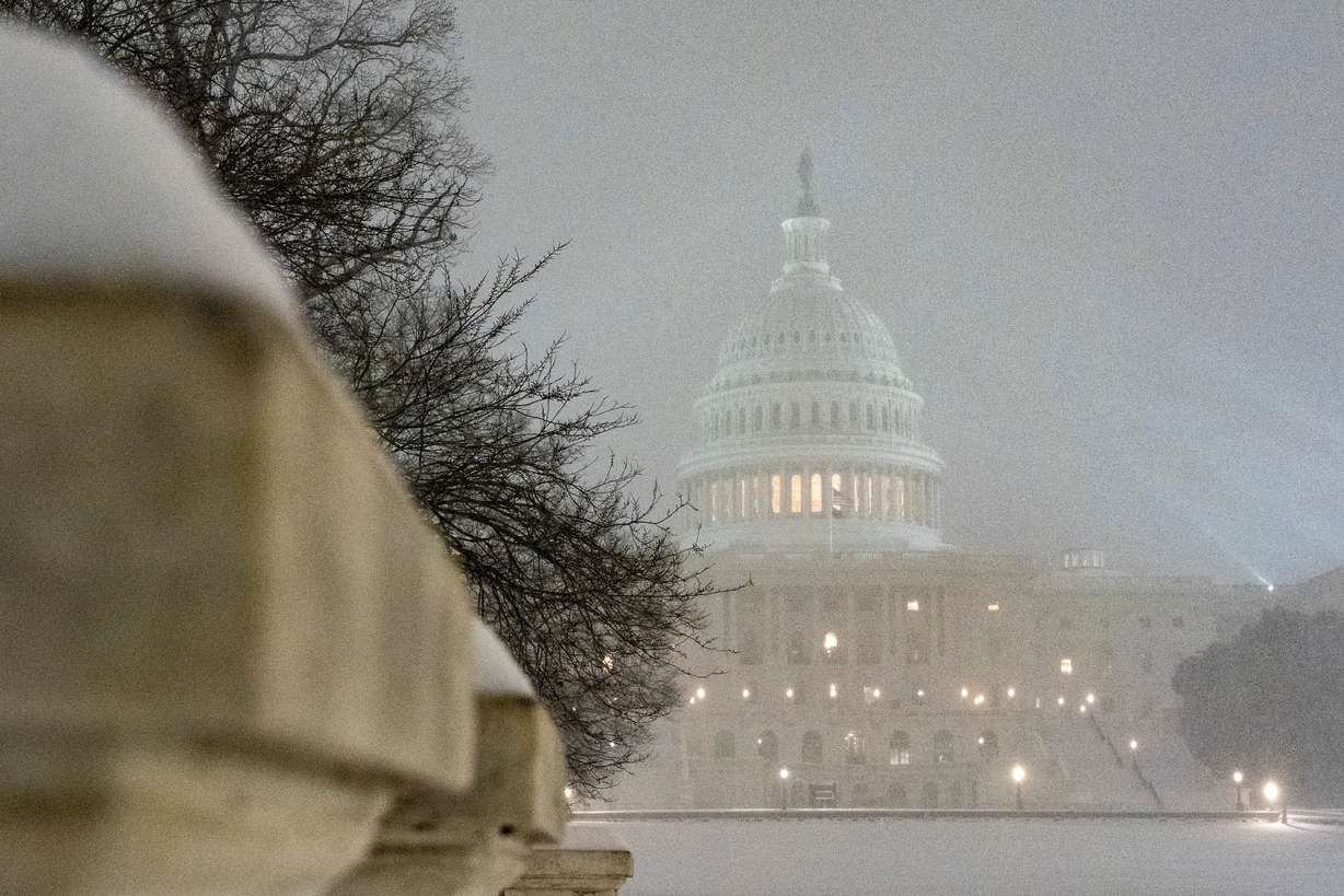 The U.S. Capitol is seen as snow falls, Sunday, in Washington.