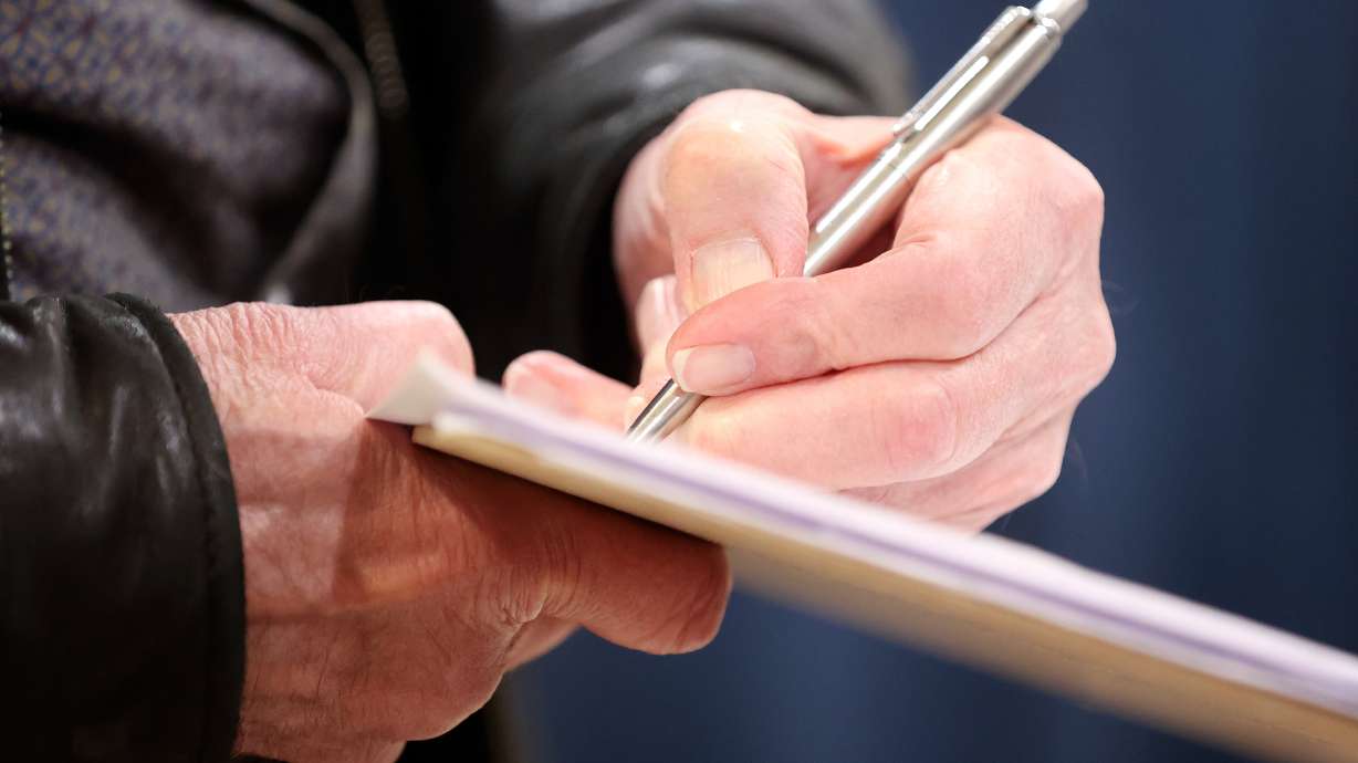 Bob Cohenour signs a petition in Midway on March 11, 2024. A legislative committee voted Monday not to advance a bill that would have decentralized responsibility for verifying signatures to qualify candidates for the primary ballot in state elections.