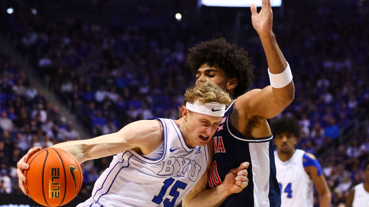 BYU guard Richie Saunders (15) drives to the basket against Arizona Wildcats forward Koa Peat (10) during the first half of an NCAA basketball game at the Marriott Center in Provo on Monday, Jan. 26, 2026.