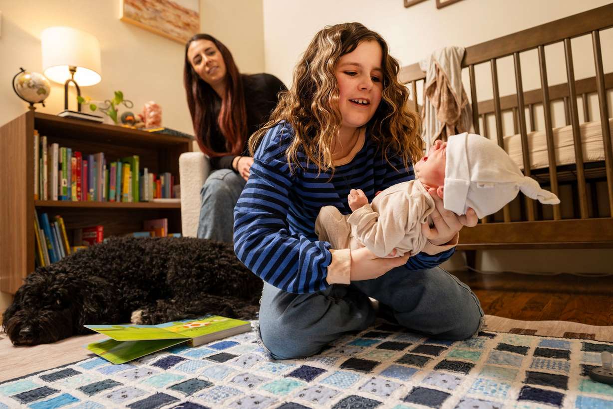 Murphy Goodwin picks up her baby brother, Vincent Golden Goodwin, as she and her parents, Jeff Goodwin and Bre Goodwin, pose for photos at home in Bountiful on Saturday. The Goodwins lost two babies, son JR (or Little Jeff) Goodwin (January 2019) and daughter Amber Rae Goodwin (November 2020), within hours of their births after both were born with no kidneys. They were told it wouldn't happen twice.