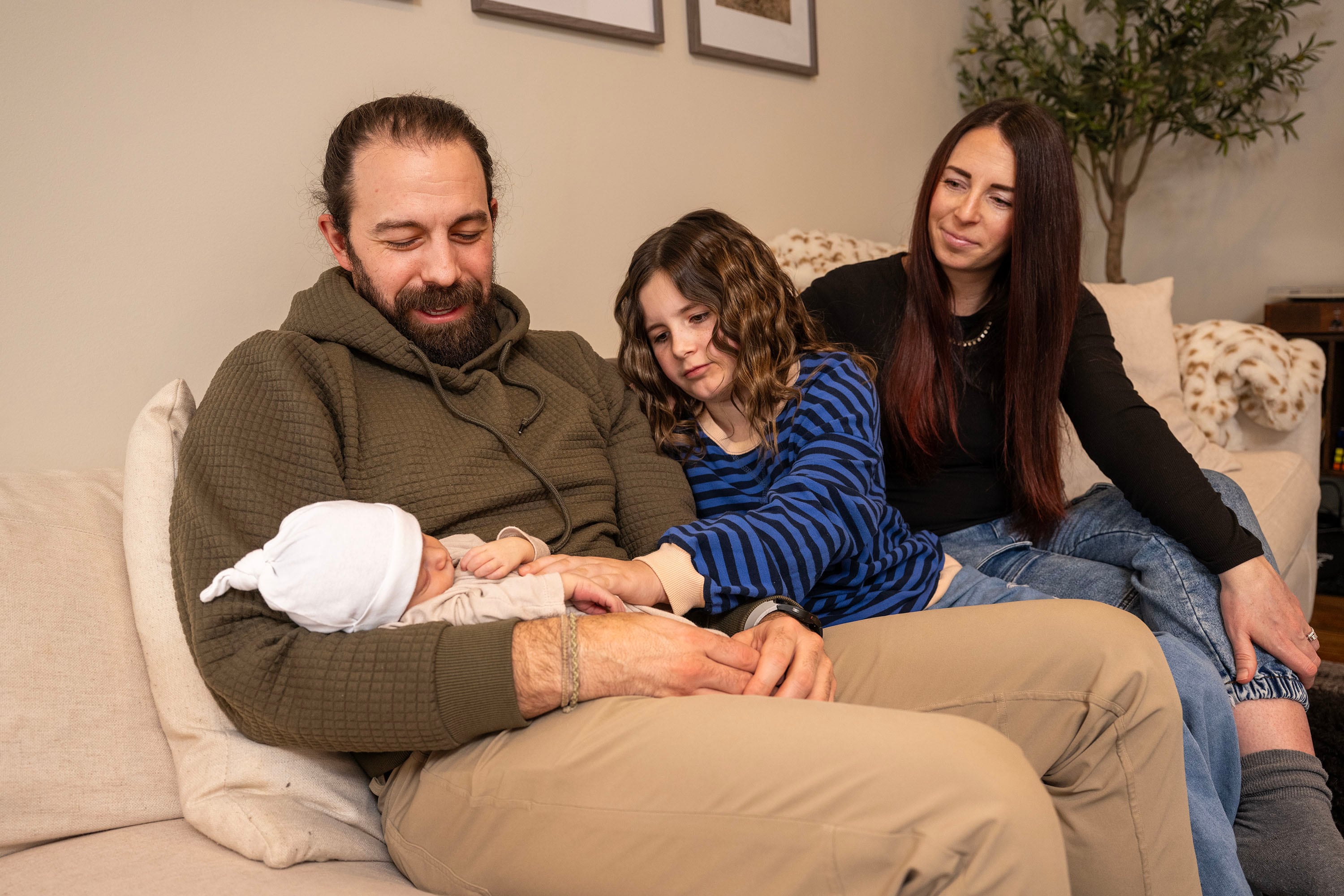 Jeff Goodwin holds his newborn son, Vincent Golden Goodwin, as he, his wife, Bre Goodwin, and their daughter Murphy Goodwin pose for photos at home in Bountiful on Saturday.