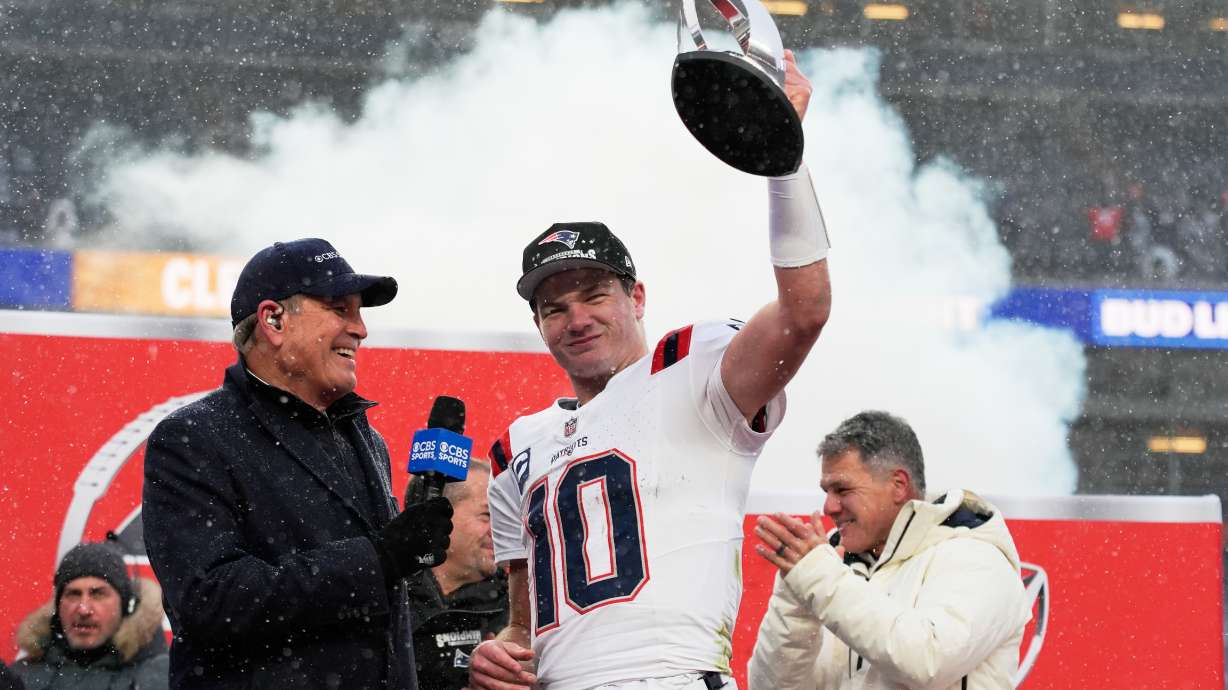 New England Patriots quarterback Drake Maye celebrates with the trophy after the AFC Championship NFL football game between the Denver Broncos and the New England Patriots, Sunday, Jan. 25, 2026, in Denver.