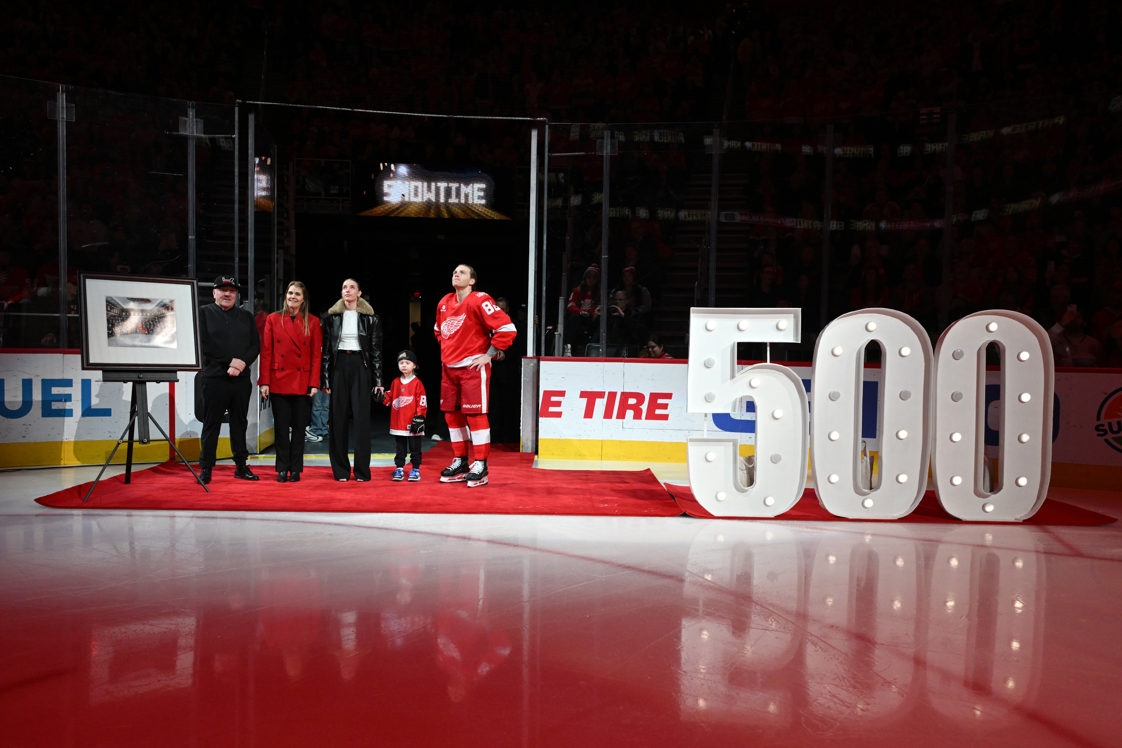 Detroit Red Wings right wing Patrick Kane (88) stands with his family, from left to right, father Patrick Sr., mother Donna, girlfriend Amanda Grahovec, and son Patrick III while being honored by the team for scoring his 500th career goal earlier in the month before an NHL hockey game against the Ottawa Senators, Sunday, Jan. 18, 2026, in Detroit. 
