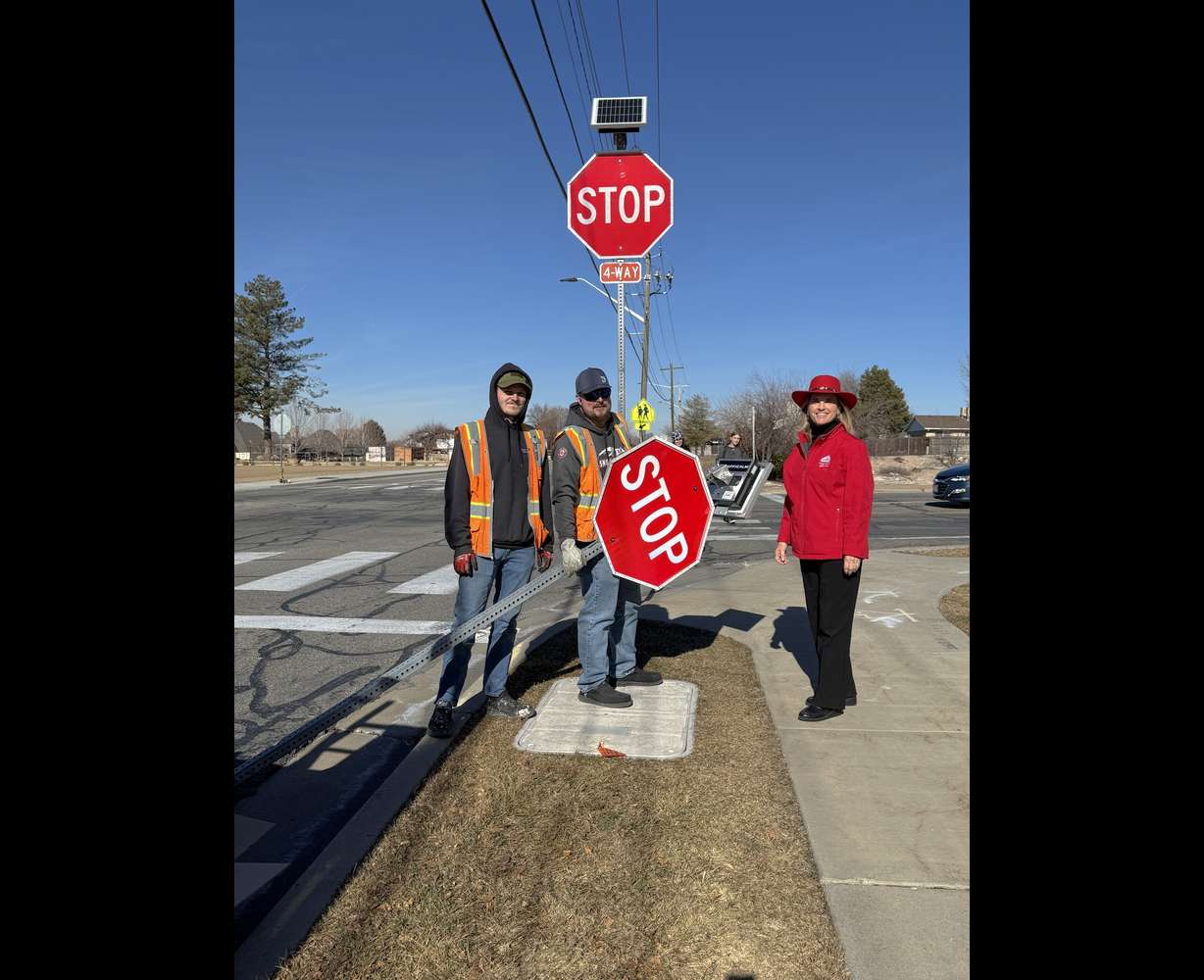 Sandy Mayor Monica Zoltanski and public works crews pose for a photo in front of newly installed LED four-way stop lighting system on Tuesday, Jan. 27, 2026 at an intersection where man was hit and killed earlier this month.