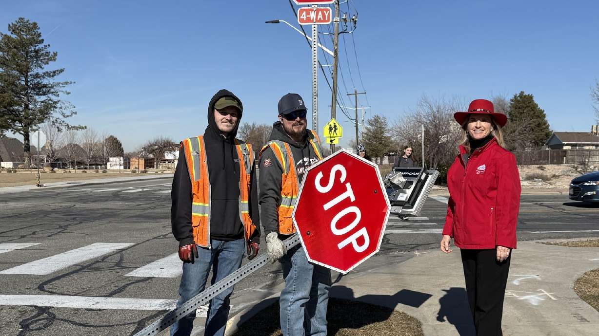 Sandy Mayor Monica Zoltanski and public works crews pose in front of the newly installed LED four-way stop lighting system on Tuesday at an intersection where a man was hit and killed earlier this month.