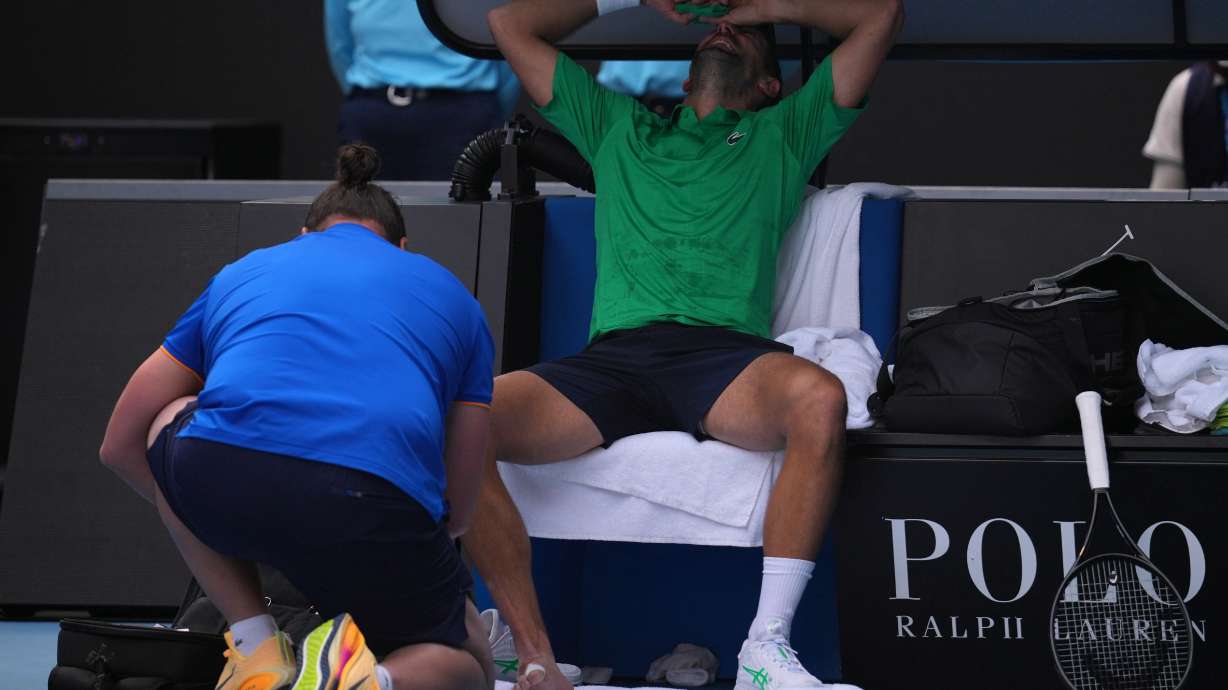 Novak Djokovic of Serbia reacts as he receives treatment to a foot injury during his quarterfinal match against Lorenzo Musetti of Italy at the Australian Open tennis championship in Melbourne, Australia, Wednesday, Jan. 28, 2026.