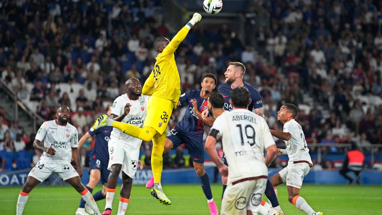 FILE - Lorient's goalkeeper Yvon-Lamdry Mvogo punches the ball clear during the French League One soccer match between Paris Saint-Germain and Lorient at the Parc des Princes stadium in Paris, Aug. 12, 2023.