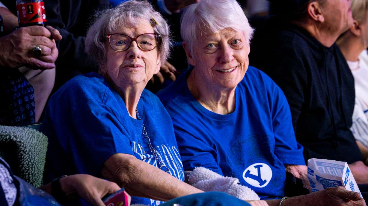 Penny Spresser, 86, left, poses with her sister, Dixie Grimmett, 89, for a photo during an NCAA basketball game between BYU and Utah held at the Marriott Center in Provo on Jan. 24.