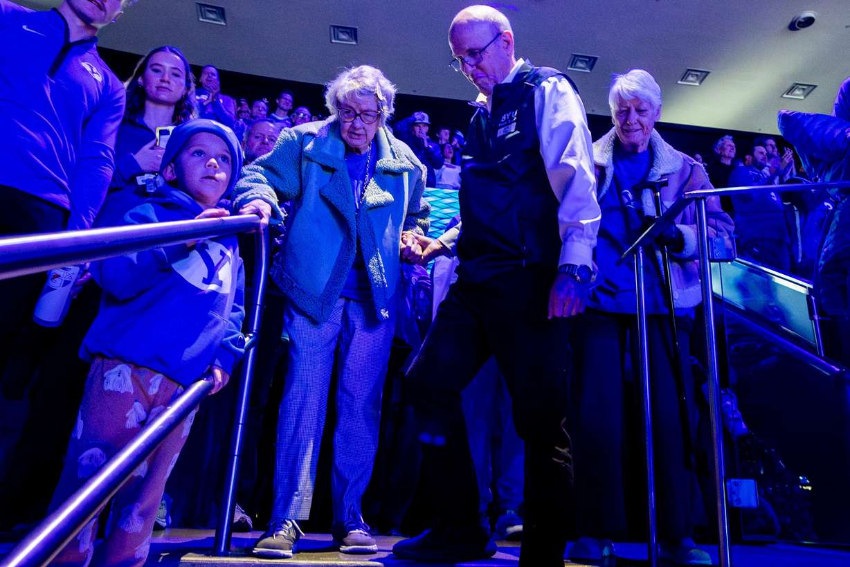 Penny Spresser, 86, is helped down the stairs by guest services usher Tim Osborn as Spresser and her sister, Dixie Grimmett, 89, make their way to their seats before an NCAA men’s basketball game between BYU and Utah held at the Marriott Center in Provo on Jan. 24.