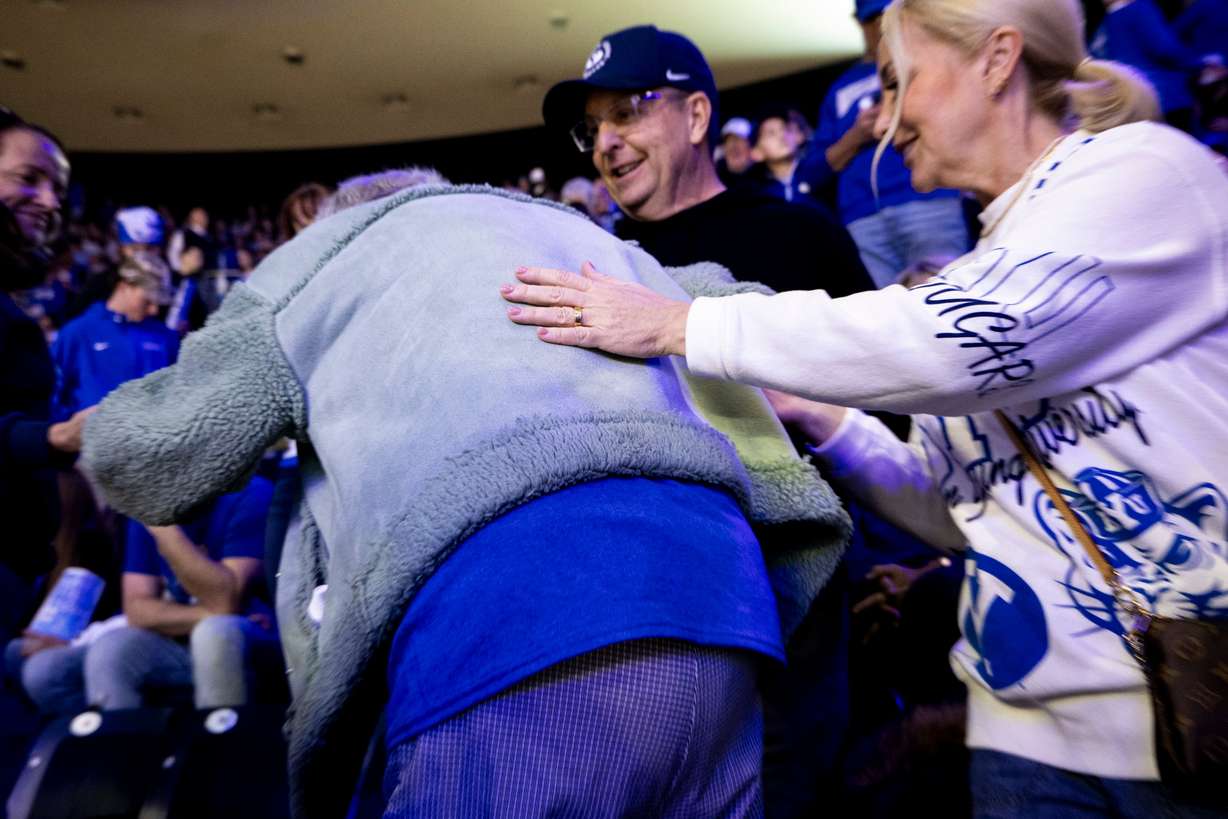 Fellow fans help Penny Spresser, 86, to her seat before an NCAA men’s basketball game between BYU and Utah held at the Marriott Center in Provo on Jan. 24.