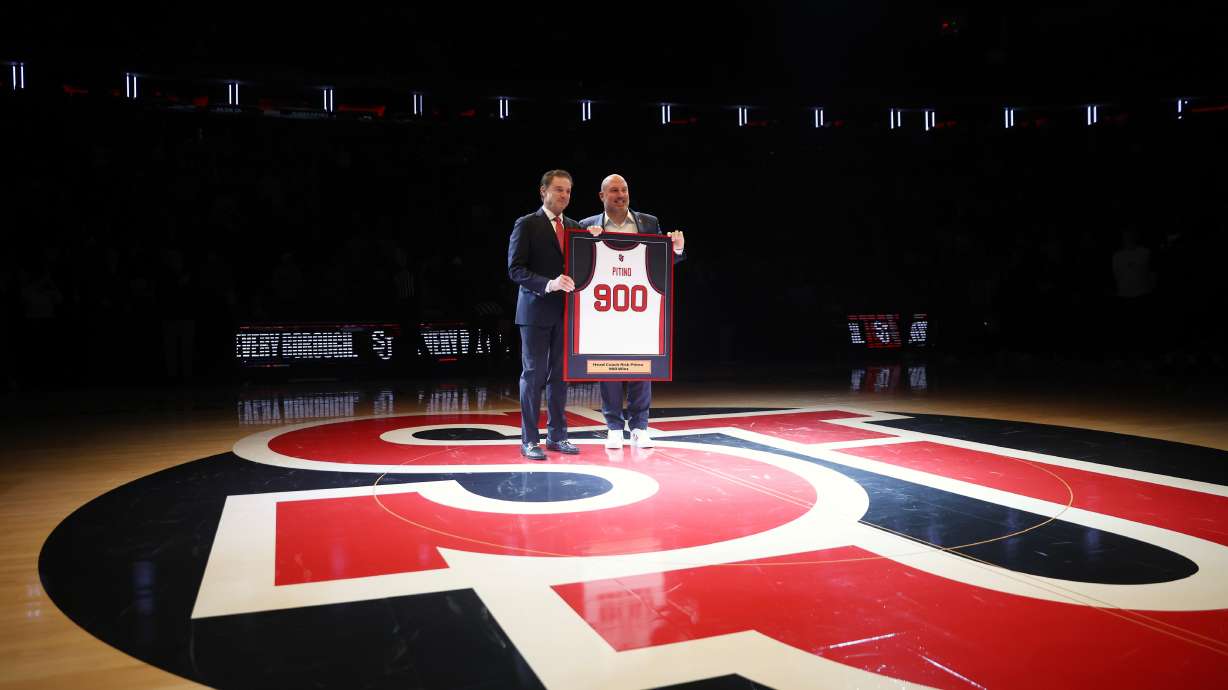 St. John's head coach Rick Pitino, left, is presented with a jersey by Ed Kull for his 900th win before an NCAA college basketball game against Butler, Wednesday, Jan. 28, 2026, in New York.