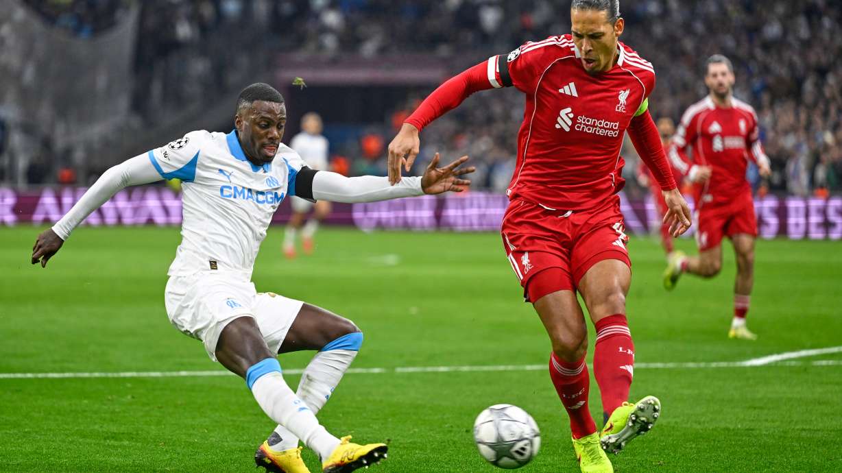 Liverpool's Virgil van Dijk kicks the ball ahead of Marseille's Timothy Weah, left, during the Champions League opening phase soccer match between Marseille and Liverpool in Marseille, France, Wednesday, Jan. 21, 2026.