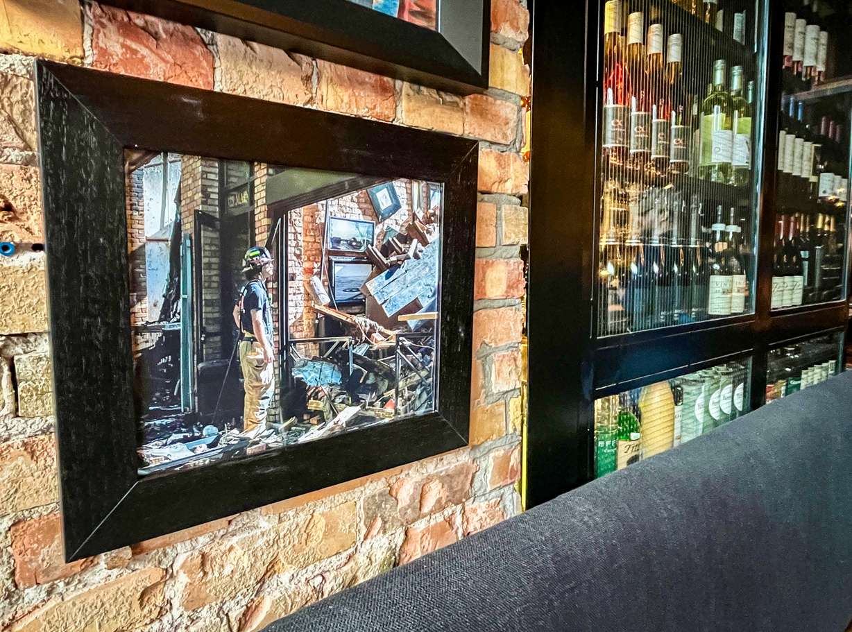 A photo of a firefighter inspecting damage at White Horse Spirits & Kitchen last year hangs on the wall of the restaurant on Thursday. The fire heavily damaged the business.