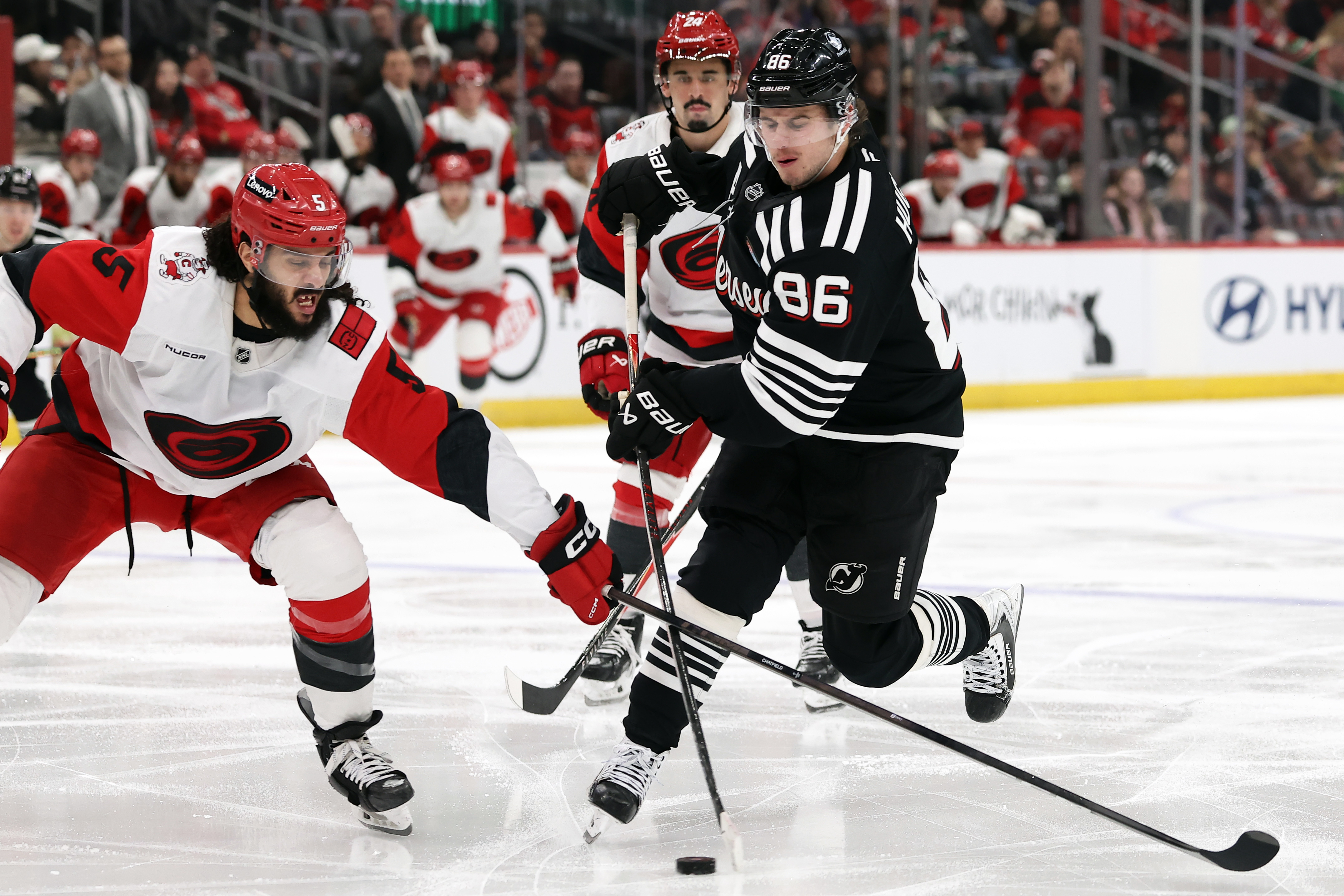 New Jersey Devils center Jack Hughes (86) has his shot knocked away by Carolina Hurricanes defenseman Jalen Chatfield (5) during the second period of an NHL hockey game Saturday, Jan. 17, 2026, in Newark, N.J. 