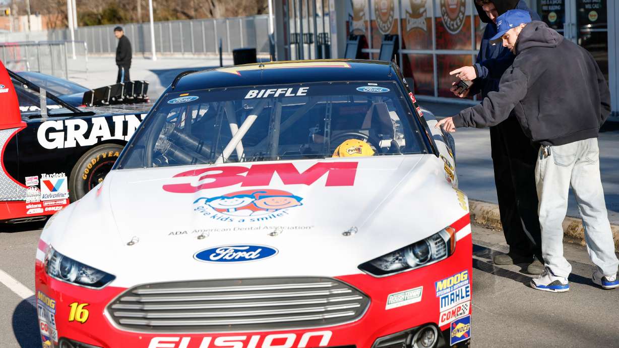 Bailey Kitchens, right, and Noah Teer look at a race car of the late Greg Biffle before a NASCAR Plane Crash Memorial memorial for him, his family and others who died in a plane crash, in Charlotte, N.C., Friday, Jan. 16, 2026.