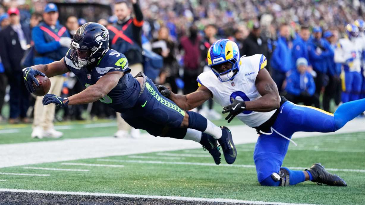 Seattle Seahawks running back Kenneth Walker III (9) scores a touchdown past Los Angeles Rams linebacker Byron Young (0) during the first half of the NFC Championship NFL football game Sunday, Jan. 25, 2026, in Seattle.