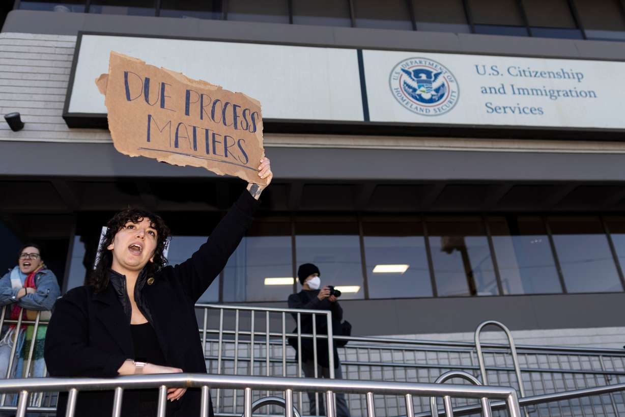 A protester holds up a sign saying “due process matters” outside of the U.S. Citizenship and Immigration Services building during an anti-ICE protest in Salt Lake City on Friday.