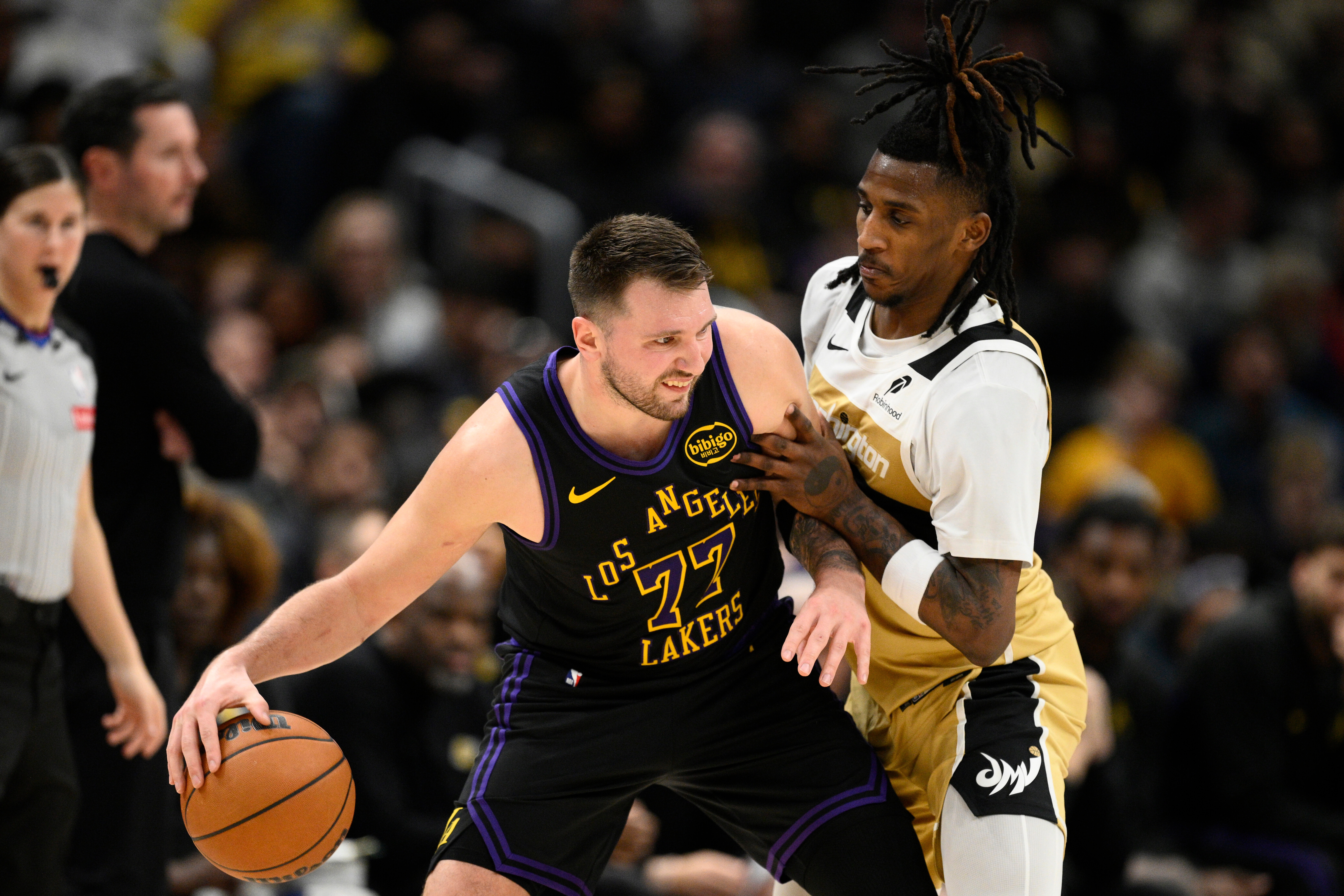 Los Angeles Lakers guard Luka Doncic (77) dribbles against Washington Wizards guard Jamir Watkins, right, during the first half of an NBA basketball game, Friday, Jan. 30, 2026, in Washington. 