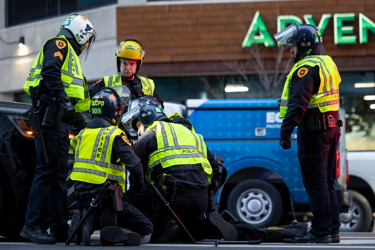 Police detain an anti-ICE protester near the Wallace F. Bennett Federal Building in Salt Lake City on Friday.