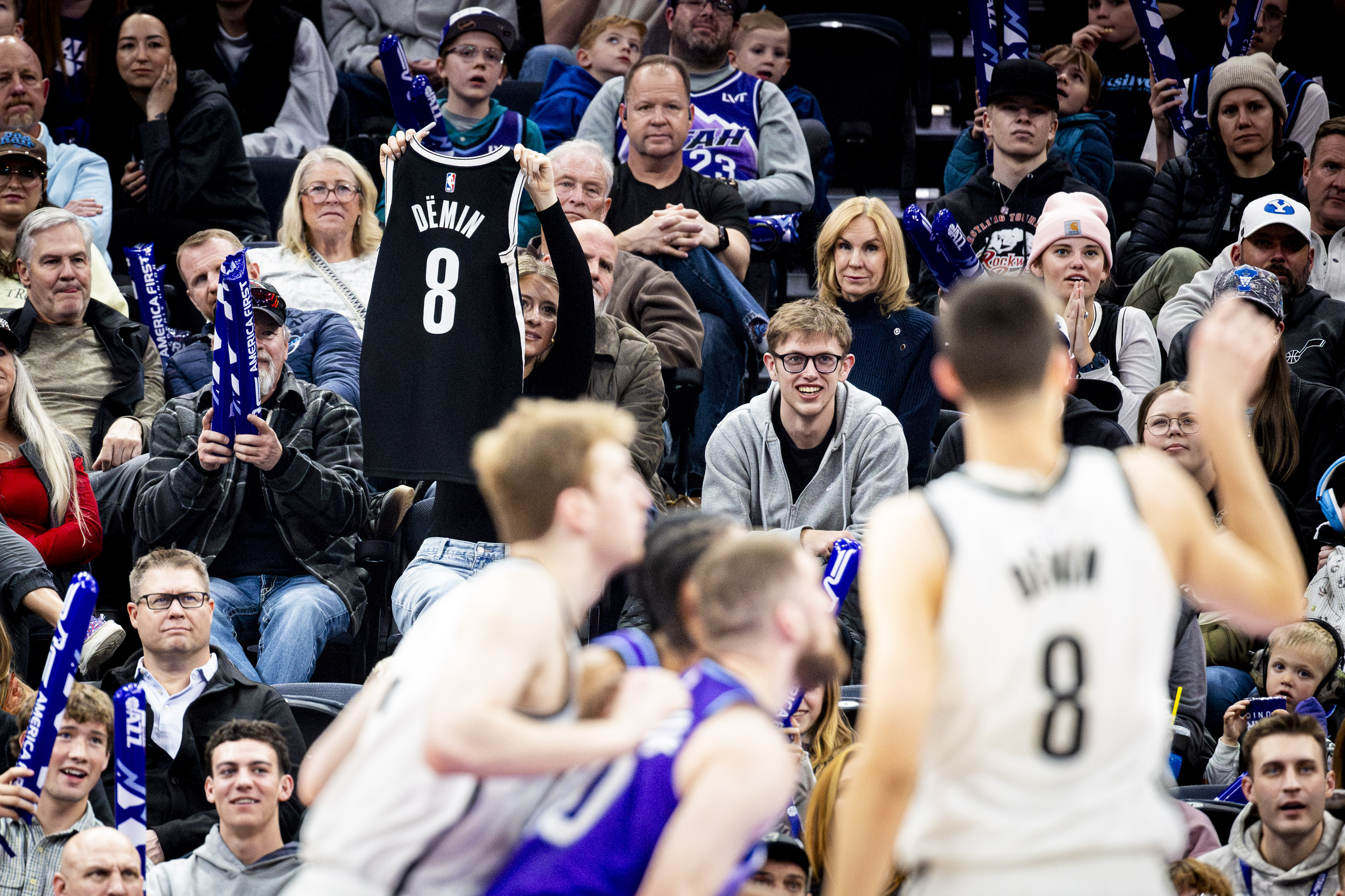 A fan holds up a jersey of Brooklyn Nets guard Egor Dëmin (8) as Dëmin takes a foul shot during an NBA game against the Utah Jazz held at the Delta Center in Salt Lake City on Friday, Jan. 30, 2026.