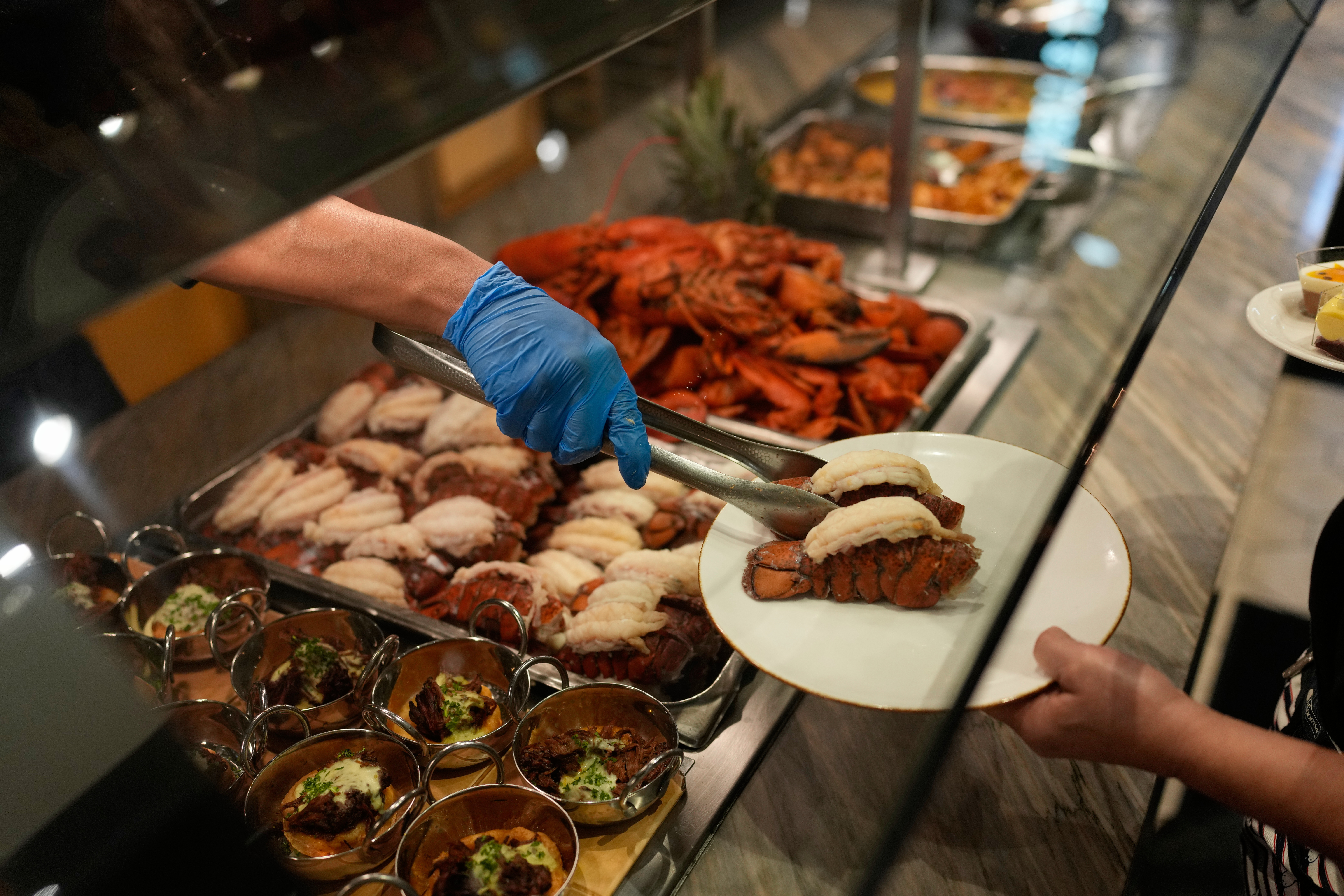 A person serves lobster tails at the A.Y.C.E Buffet in the Palms resort-casino Wednesday in Las Vegas.  