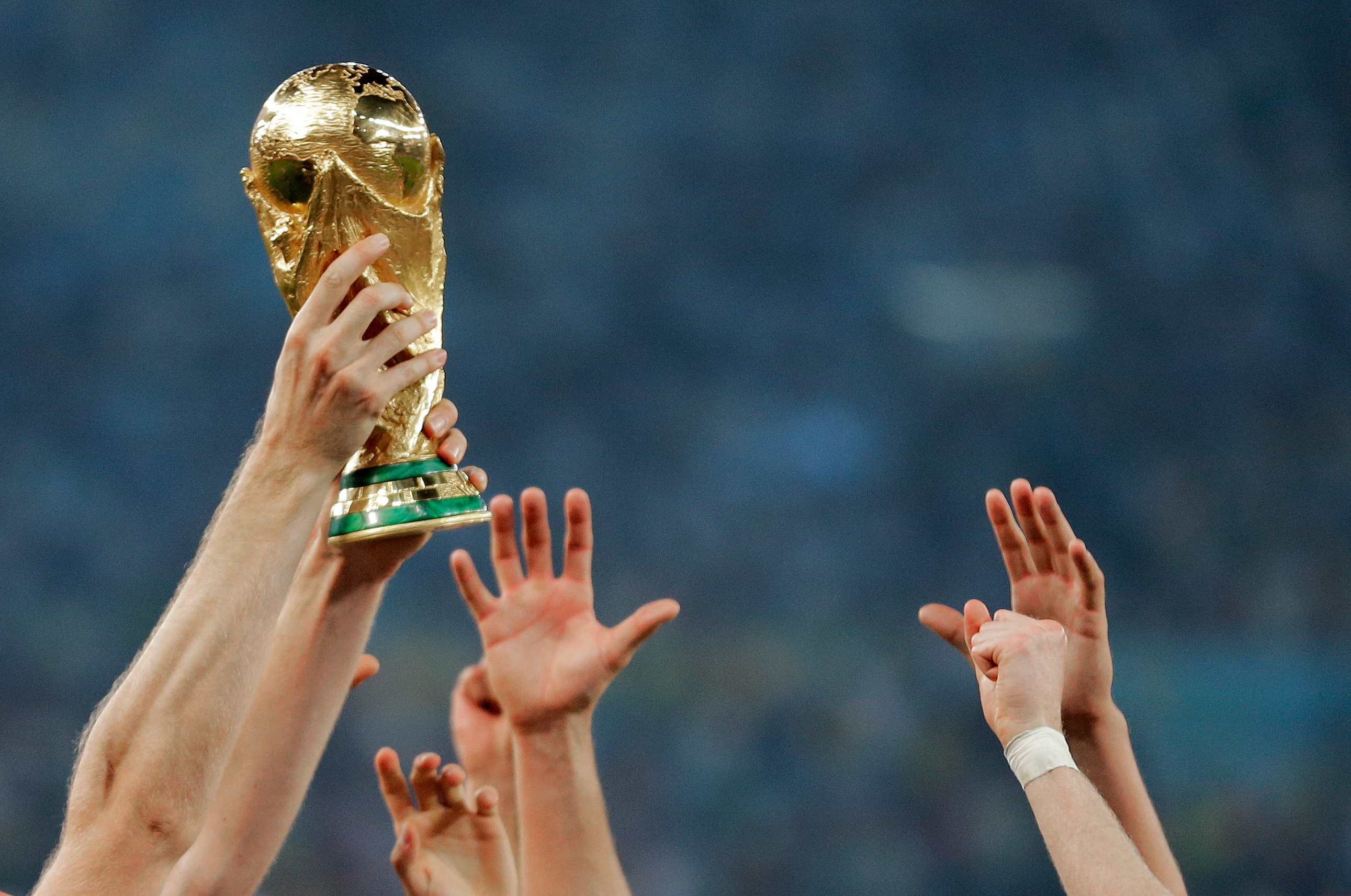 FILE - German players reach out to touch the trophy after the World Cup final soccer match between Germany and Argentina, in Rio de Janeiro, Brasil, July 13, 2014. 