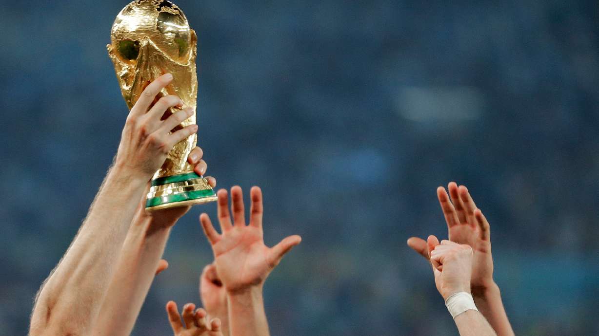 FILE - German players reach out to touch the trophy after the World Cup final soccer match between Germany and Argentina, in Rio de Janeiro, Brasil, July 13, 2014.