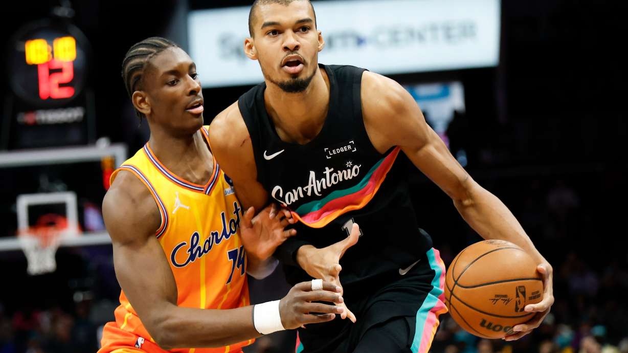 San Antonio Spurs forward Victor Wembanyama, right, moves the ball against Charlotte Hornets forward Moussa Diabate during the first half of an NBA basketball game in Charlotte, N.C., Saturday, Jan. 31, 2026.