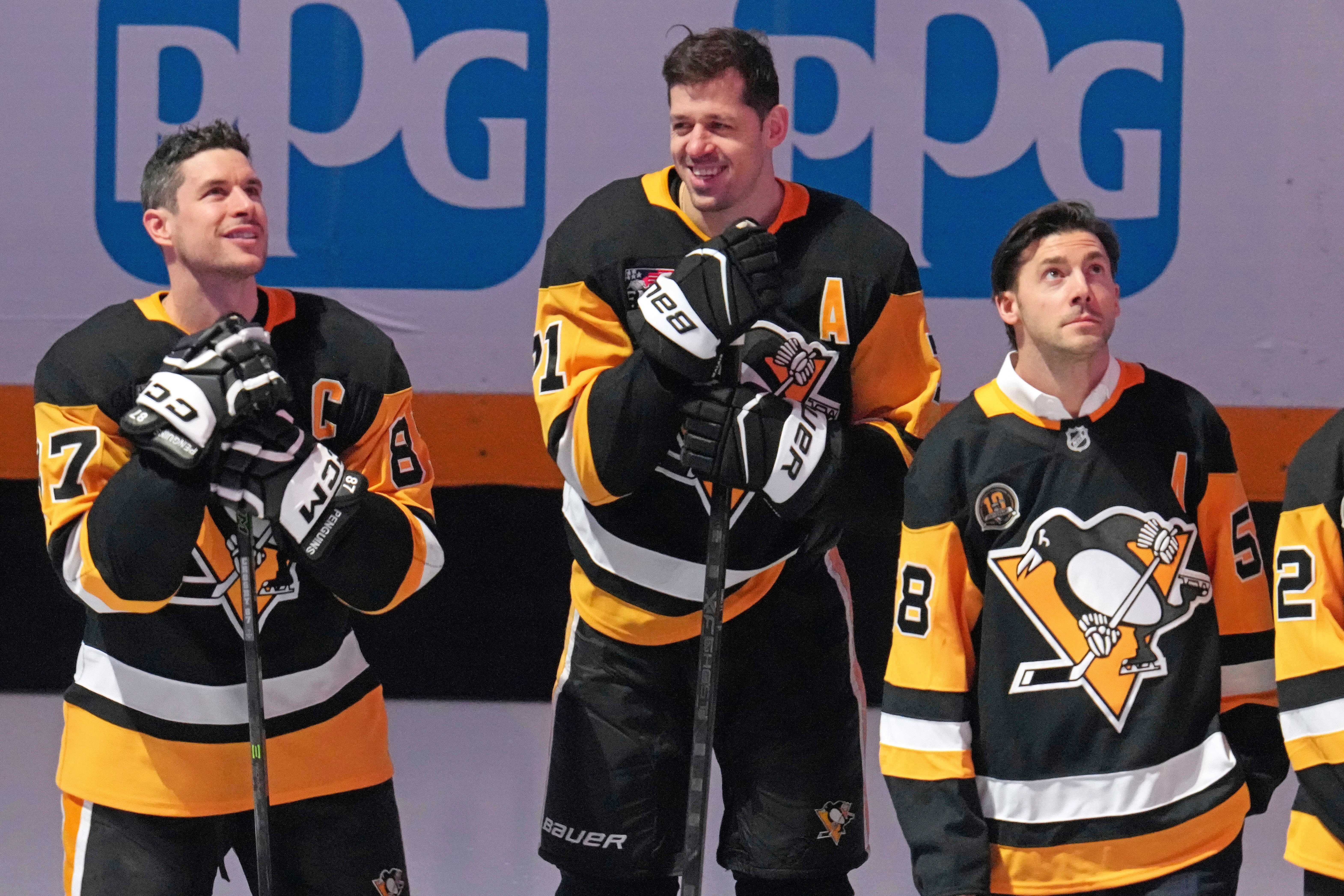 Members of the 2016 Stanley Cup Champion Pittsburgh Penguins, Sidney Crosby, left, Evgeni Malkin, center, and Kris Letang take part in a celebration of the 10th anniversary before an NHL hockey game against the New York Rangers in Pittsburgh, Saturday, Jan. 31, 2026. 