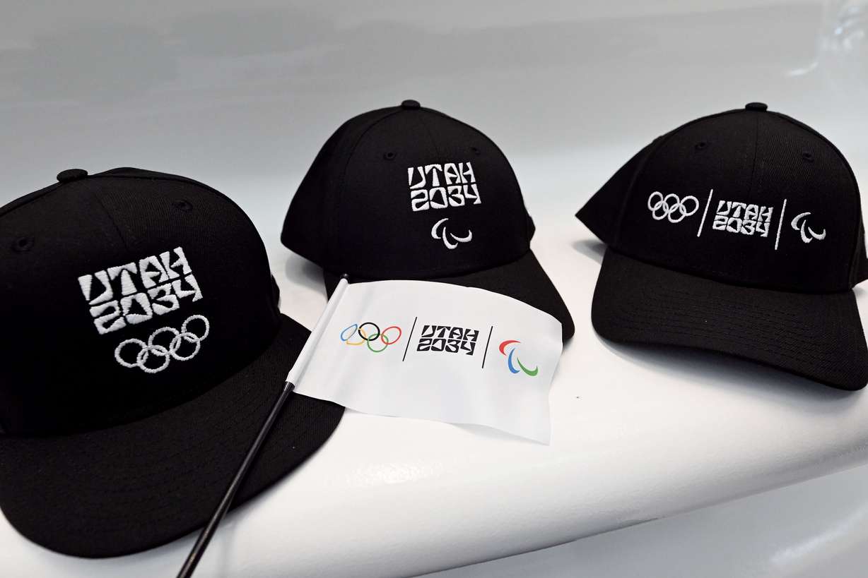 A sample of Olympic hats are shown as members of the Organizing Committee for the 2034 Olympic and Paralympic Winter Games, state and local leaders, and former athletes gather to celebrate 3,000 days until the 2034 Winter Olympics during a ceremony at the Salt Lake City International Airport on Nov. 24, 2025.