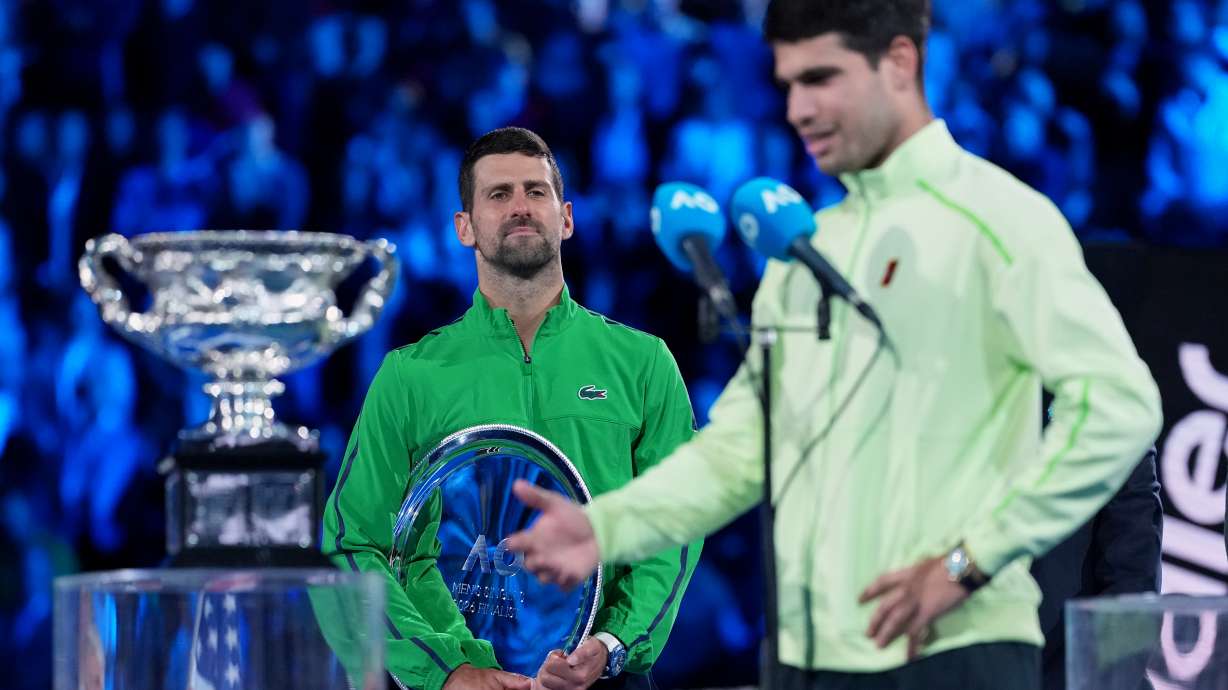 Novak Djokovic of Serbia watches Carlos Alcaraz of Spain give his victory speech after winning the men's singles final at the Australian Open tennis championship in Melbourne, Australia, Sunday, Feb. 1, 2026.