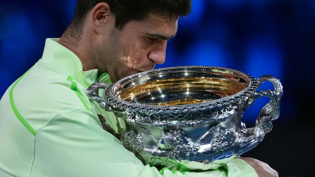 Carlos Alcaraz of Spain holds the Norman Brookes Challenge Cup after defeating Novak Djokovic of Serbia in the men's singles final at the Australian Open tennis championship in Melbourne, Australia, Sunday, Feb. 1, 2026.