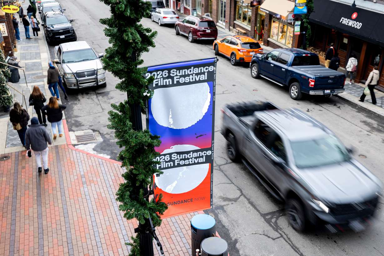 Signage for the Sundance Film Festival is displayed while traffic flows and people walk along Main Street in Park City on Jan. 2.