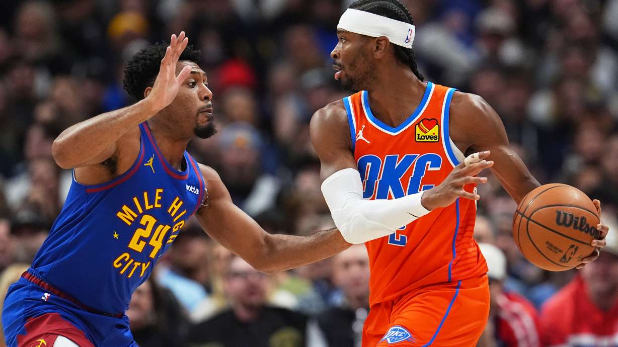 Oklahoma City Thunder guard Shai Gilgeous-Alexander, right, looks to pass the ball as Denver Nuggets guard Jalen Pickett defends in the first half of an NBA basketball game Sunday, Feb. 1, 2026, in Denver.