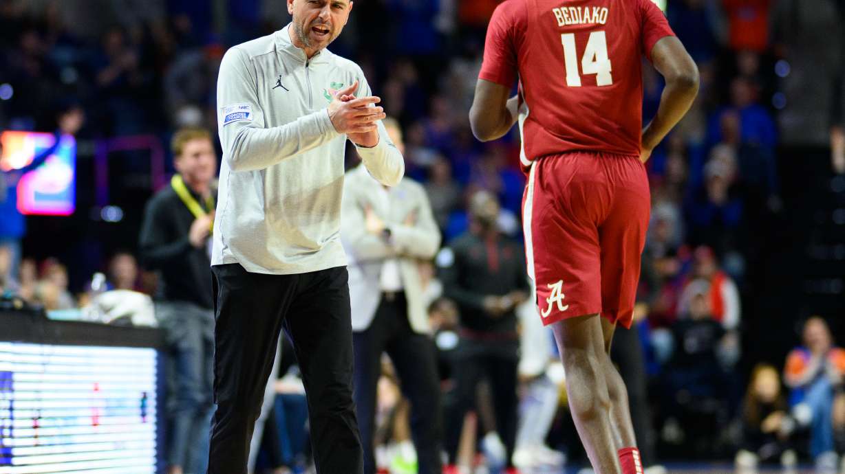 Florida head coach Todd Golden, left, claps and talks to Alabama center Charles Bediako (14) who walks off the court after fouling out during the second half of an NCAA college basketball game, Sunday, Feb. 1, 2026, in Gainesville, Fla.