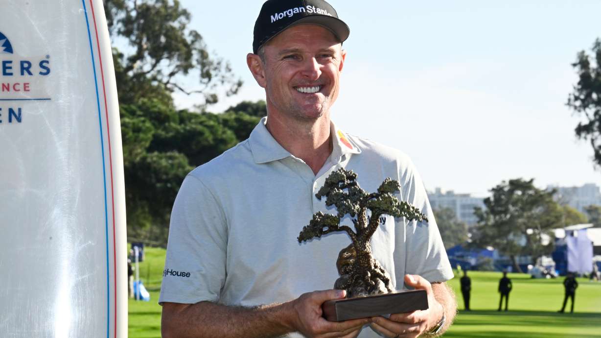 Justin Rose, of England, holds the winner's trophy at the Farmers Insurance Open golf tournament Sunday, Feb. 1, 2026, at Torrey Pines in San Diego.