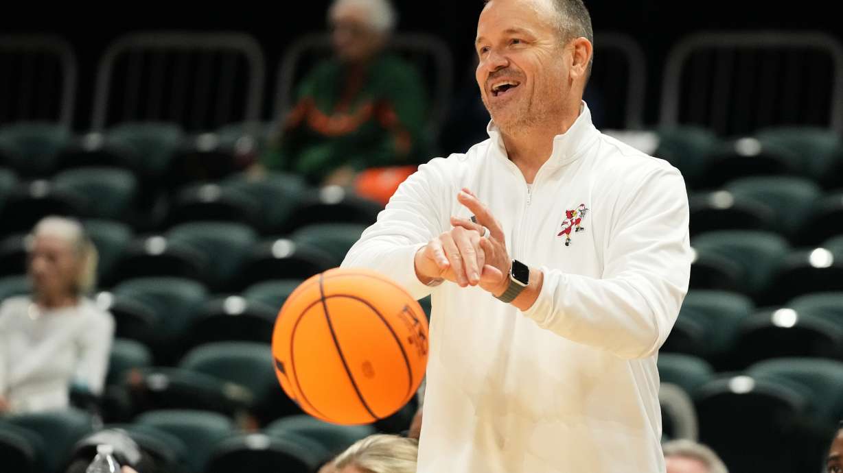 Louisville head coach Jeff Walz puts the ball back into play during the second half of an NCAA college basketball game against Miami, Thursday, Jan. 8, 2026, in Coral Gables, Fla.