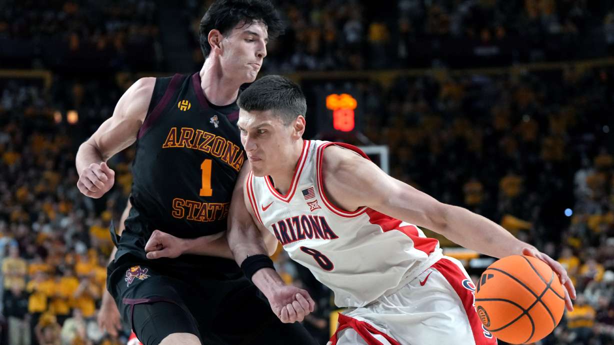 Arizona forward Ivan Kharchenkov (8) drives on Arizona State forward Santiago Trouet during the first half of an NCAA college basketball game, Saturday, Jan. 31, 2026, in Tempe, Ariz.