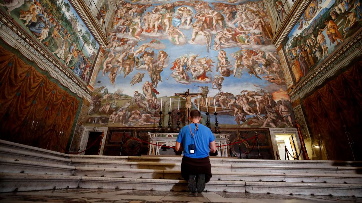A visitor kneels in front of the Last Judgement fresco by the Italian Renaissance painter Michelangelo inside the Sistine Chapel in Rome, May 3, 2021.