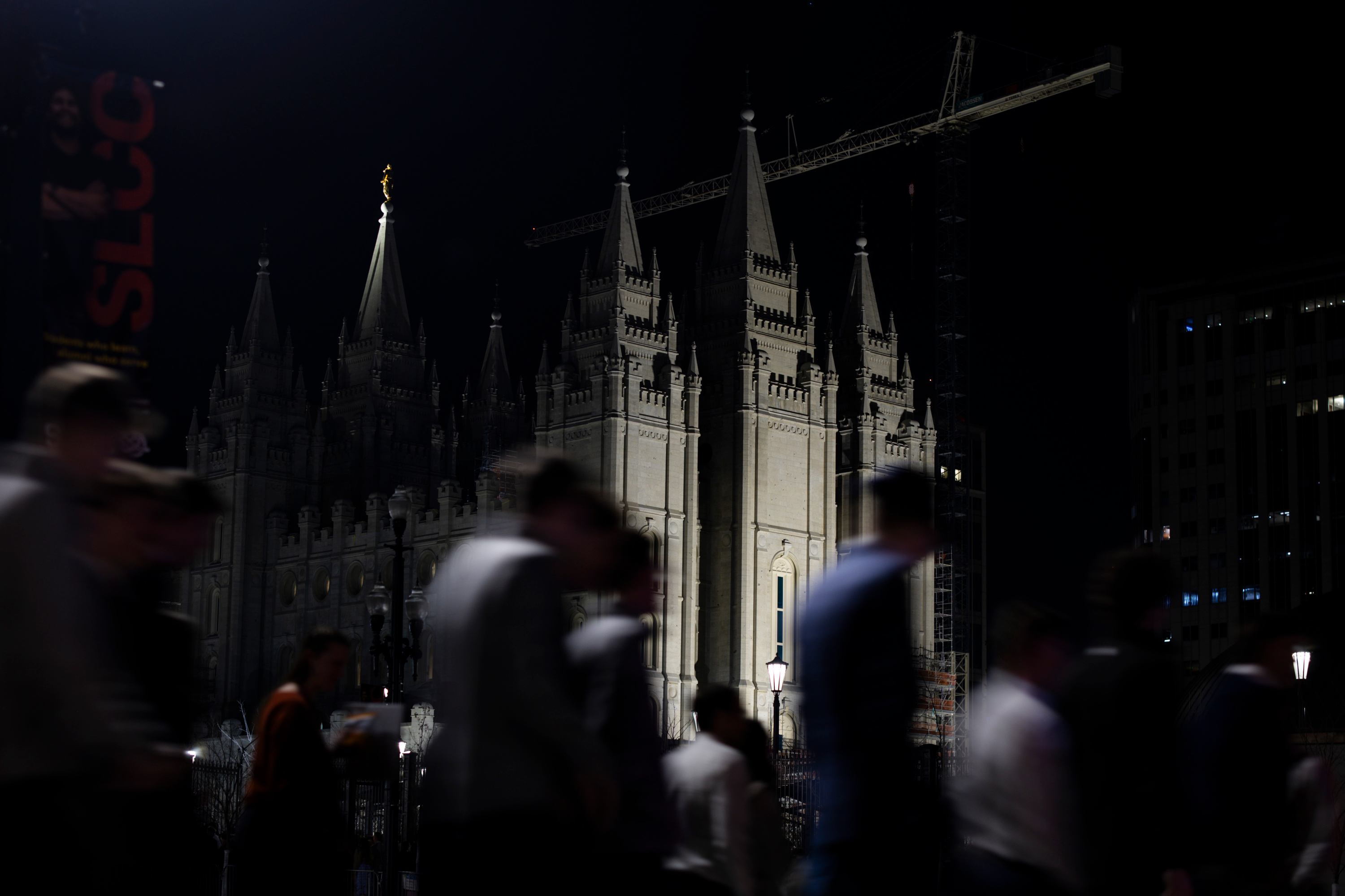 The Salt Lake Temple is illuminated as attendees exit from a Worldwide Devotional for Young Adults on Sunday. Salt Lake City is considering a few long-standing road closures for when the six-month temple open house is held in 2027.