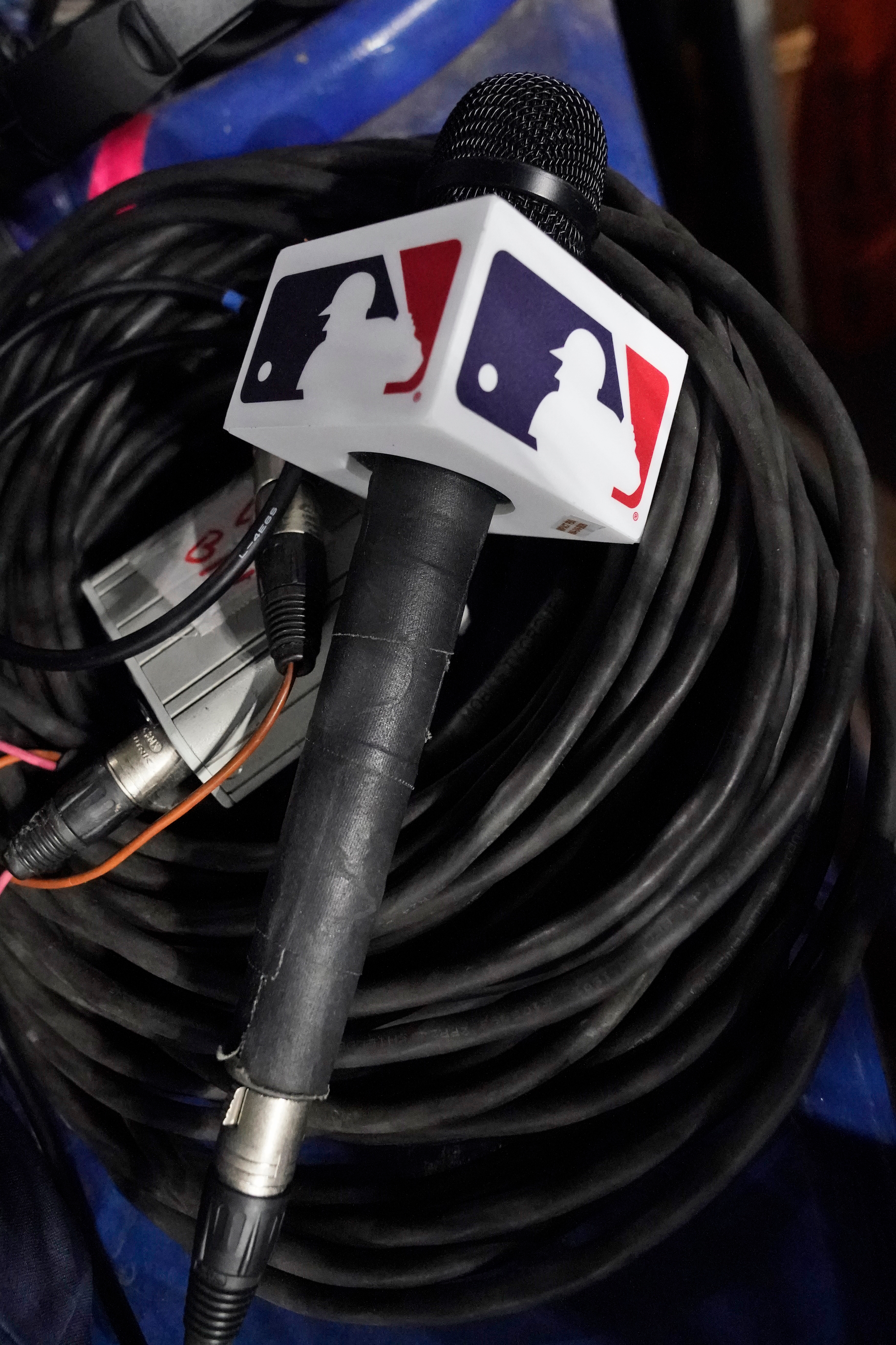 A microphone belonging to a field reporter for the San Diego Padres sits on top of audio cables during a baseball game between the Miami Marlins and the Padres, May 31, 2023, in Miami. 