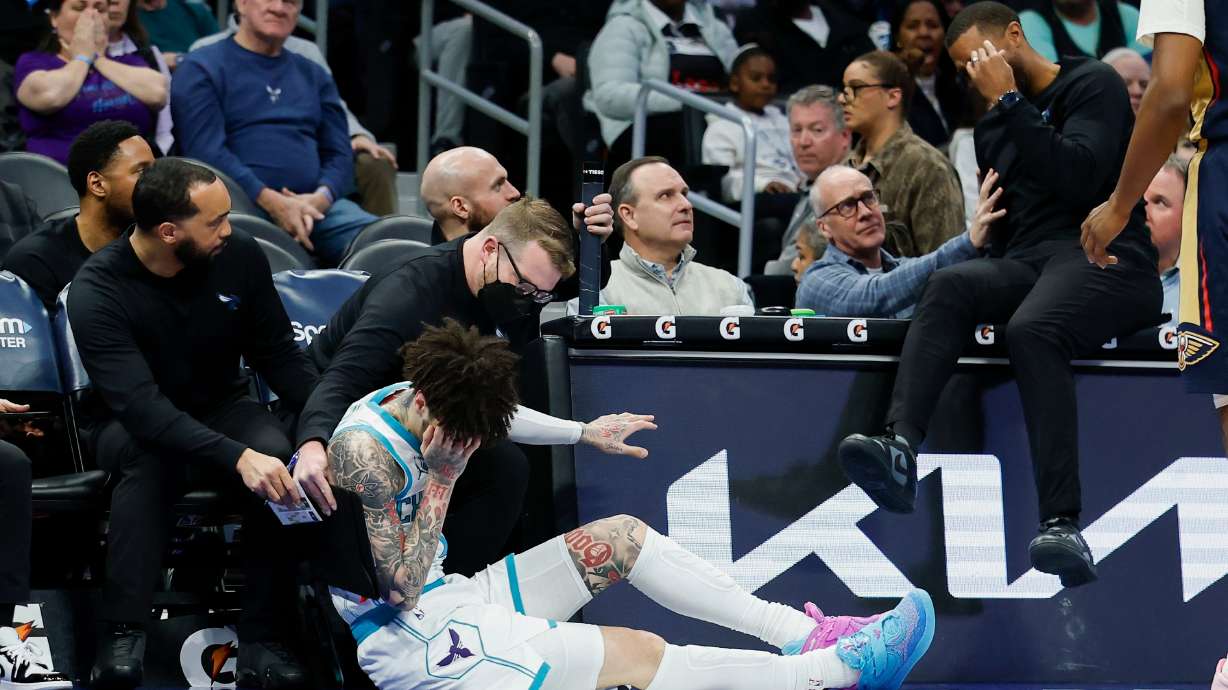 Charlotte Hornets guard LaMelo Ball holds his head after colliding with head coach Charles Lee during the first half of an NBA basketball game against the New Orleans Pelicans, in Charlotte, N.C., Monday, Feb. 2, 2026.
