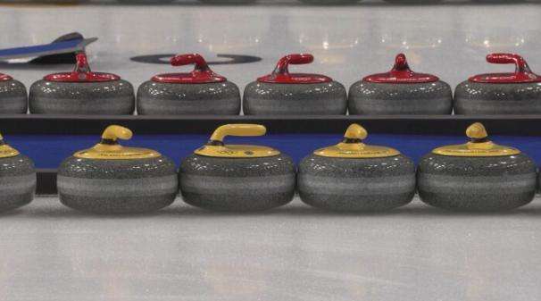 Stones sit inside the Cortina Curling Olympic Stadium.