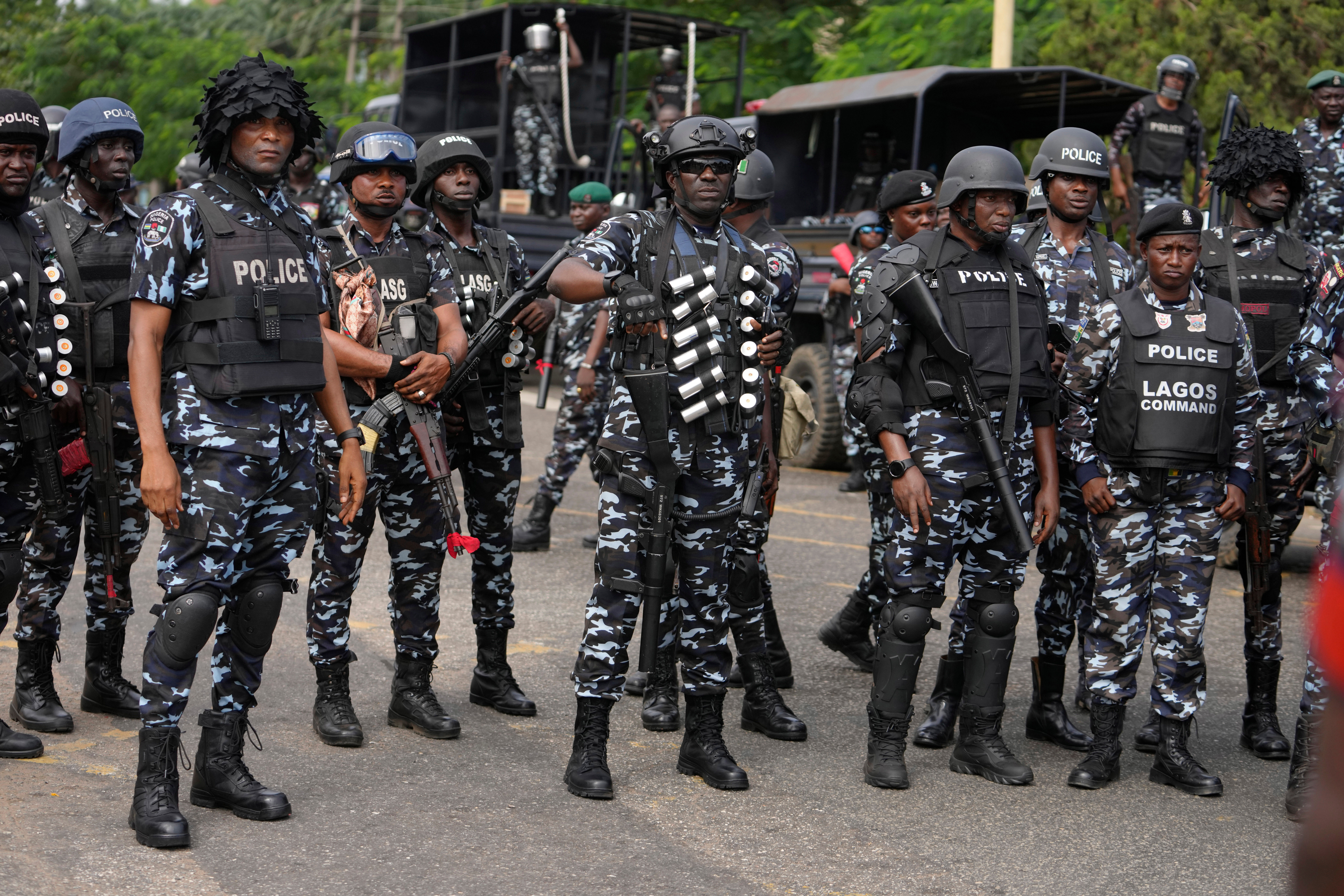 Nigeria police officers stand guard during a candle light procession in honour of all protesters killed nationwide at the recently economic hardship protest, in Lagos, Nigeria, Aug. 9, 2024. 