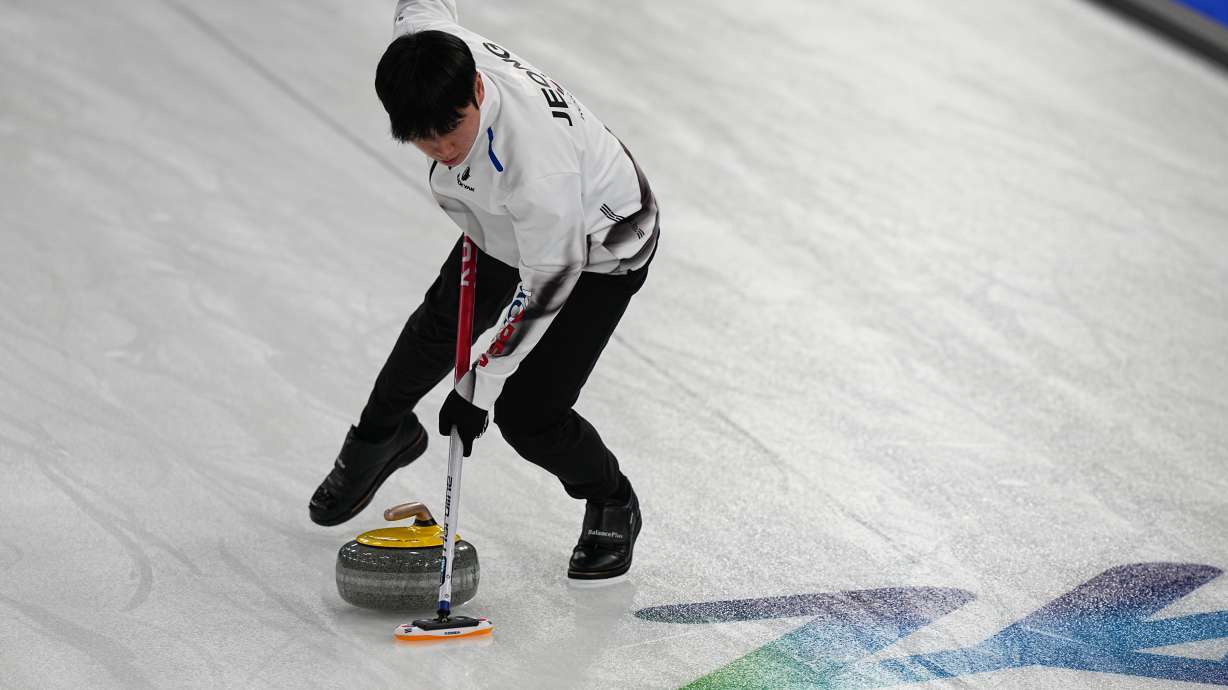 South Korea's Yeongseok Jeong sweeps a stone, during the mixed doubles round robin phase of the curling competition against Sweden, at the 2026 Winter Olympics, in Cortina d'Ampezzo, Italy, Wednesday, Feb. 4, 2026.