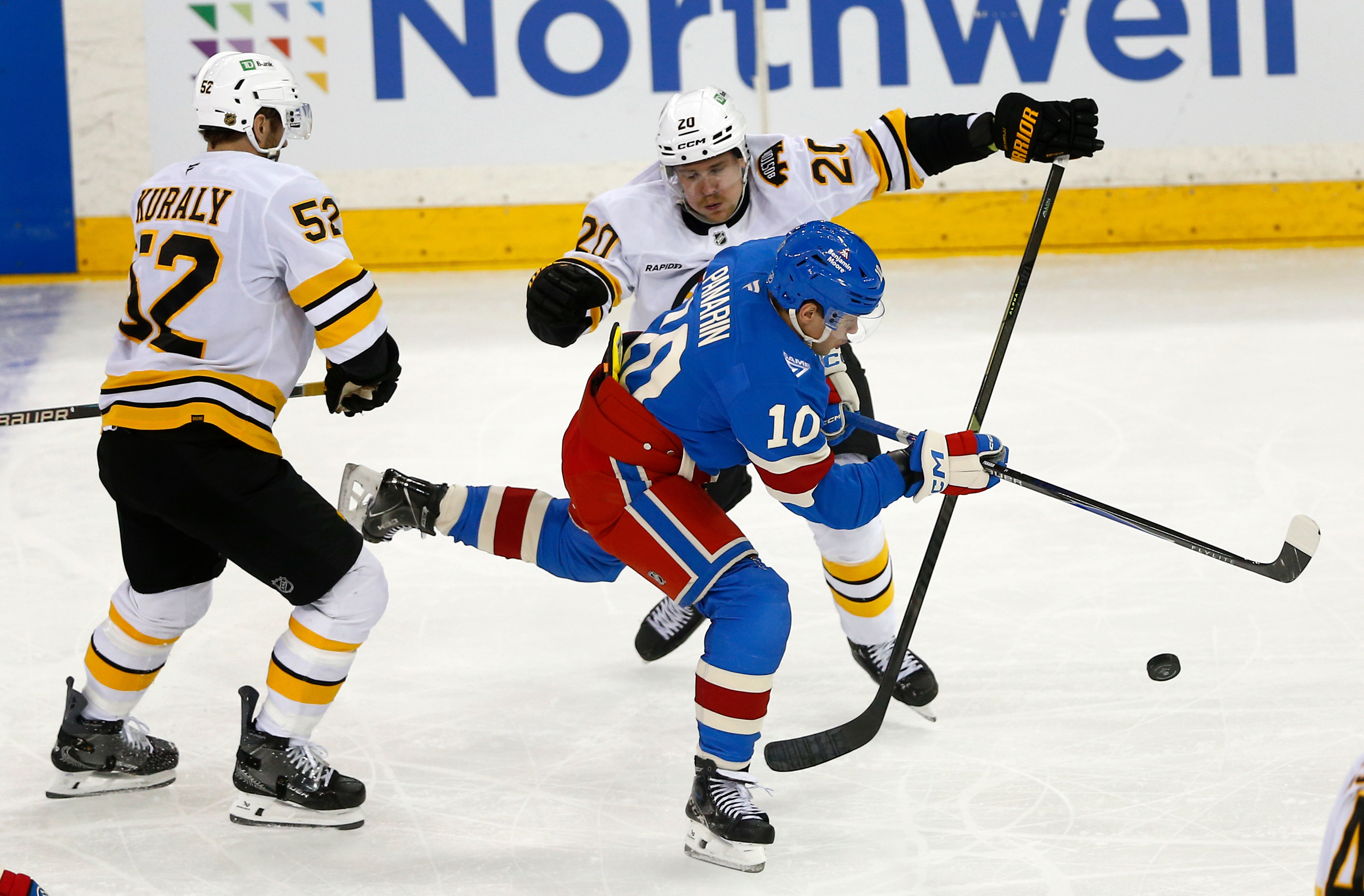 New York Rangers forward Artemi Panarin (10) skates between Boston Bruins center Sean Kuraly (52) and defenseman Henri Jokiharju (20) during the third period of an NHL hockey game Monday, Jan. 26, 2026, in New York. 